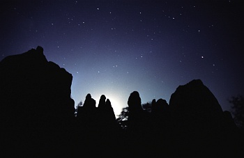 Untergehender Mond vor Felsen